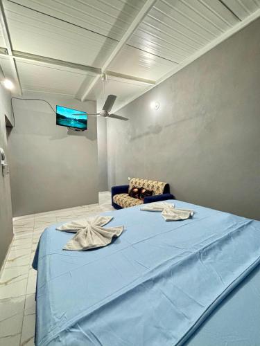 a bedroom with a blue bed and a couch at Hospedaje Paluma in Asunción