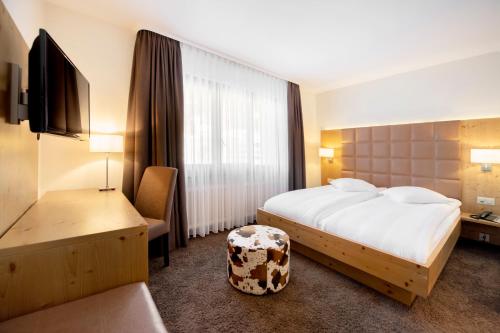 クランにあるホテル オリンピック モンタナ センターのベッドと椅子のあるホテルの部屋