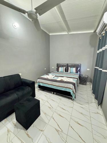 una sala de estar con una cama y un sofá en Hospedaje Ñande Roga, en Asunción
