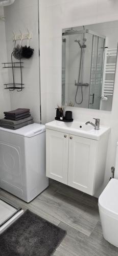 a white bathroom with a sink and a toilet at Apartamentos playa Romanilla in Roquetas de Mar