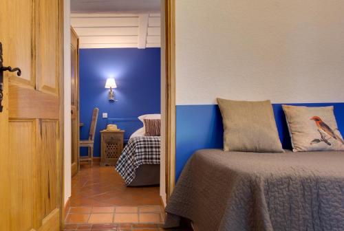 a bedroom with a bed and a blue wall at Oustau Camarguen Hôtel & Spa in Le Grau-du-Roi