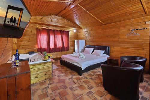 a bedroom with a bed and a tub and a sink at הבקתה הגלילית in Arbel