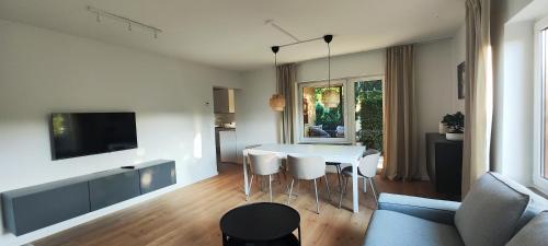 a living room with a table and chairs and a tv at Storch Appartements Limburg in Hundsangen