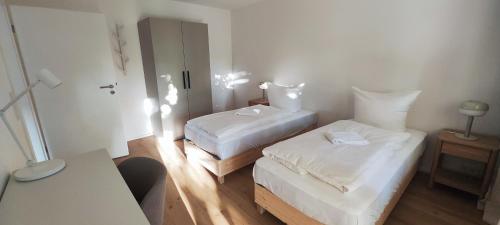 a small room with two beds and a table at Storch Appartements Limburg in Hundsangen