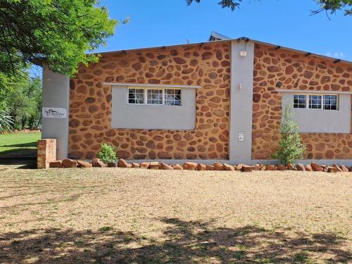 a building with two windows on the side of it at Buck Hill Bush Lodge in Maanhaarrand