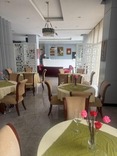 Un restaurante con mesas y sillas con flores. en Authopia Hotel, en Addis Ababa