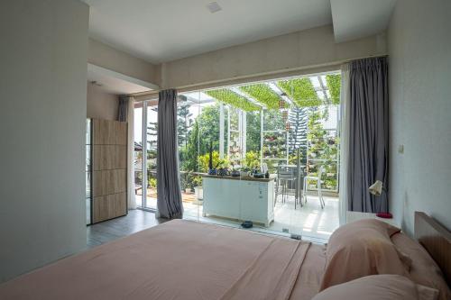 a bedroom with a bed and a large glass window at Seven Terrace in Caringin