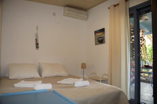 a bedroom with a bed with two towels on it at Cavo Paradise Kimolos in Kimolos