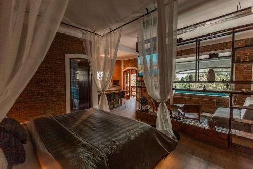 a bedroom with a bed with curtains and a window at Roteiros Adorai in Piedade