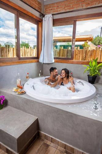 a man and woman sitting in a bath tub at Adorai Chalés in Piedade