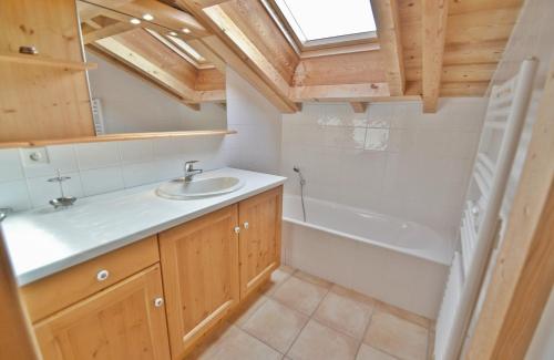 a bathroom with a sink and a bath tub at Chalet Les Sonnailles du Mont in Le Grand-Bornand
