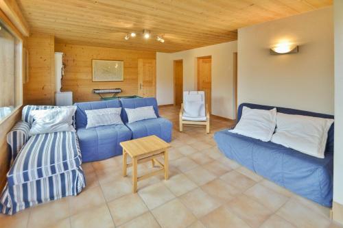 a living room with a blue couch and a table at Chalet Les Sonnailles du Mont in Le Grand-Bornand