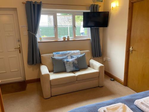 a living room with a couch with pillows on it at High View Cottage in Uttoxeter