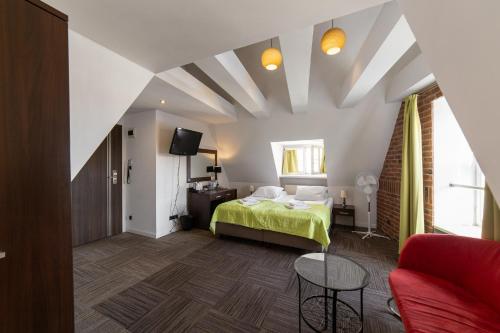 a bedroom with a green bed and a couch at Hotel Artus - Old Town in Gdańsk