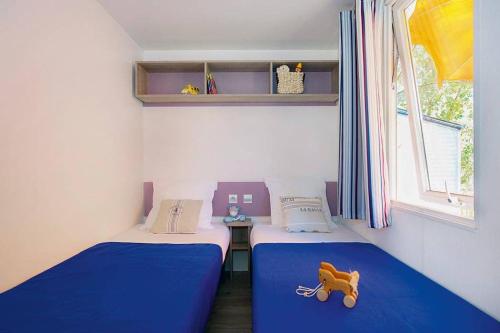 Ένα ή περισσότερα κρεβάτια σε δωμάτιο στο Homair Mobil-homes Camping Les Avignon