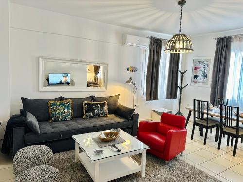 a living room with a couch and a red chair at Gianna’s apartment central Aigio Cozy and Shining in Aígio