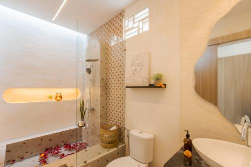 a bathroom with a toilet and a sink at The Shalak Villa Bali in Denpasar