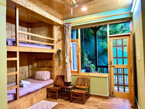a room with a bunk bed and a window at Rustic Roots Home Stay in Nagar