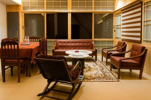 a restaurant with chairs and a table and a couch at Brookfield in Pālampur