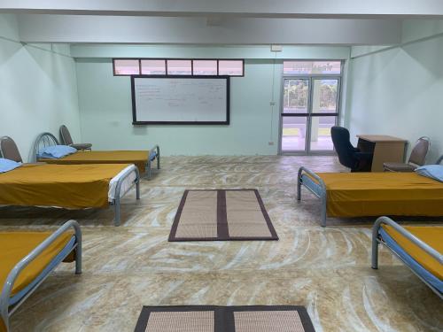 een kamer met drie bedden en een projectiescherm bij Agnes Haven in Ban Khlong Haeng