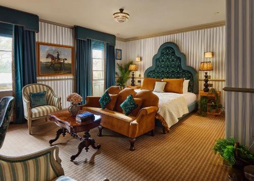 a bedroom with a bed and a couch and a chair at Brownsover Hall Hotel in Rugby