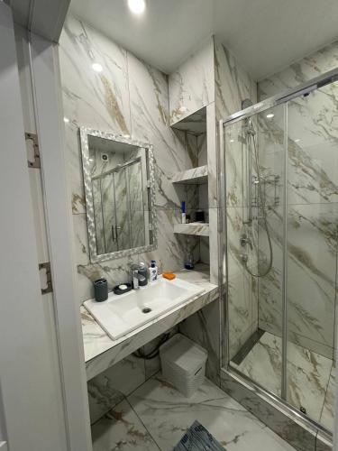 une salle de bain avec lavabo et douche dans l'établissement Квартира с евроремонтом, à Odessa