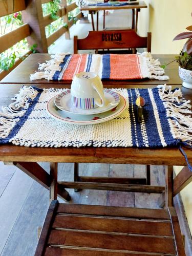 a table with a table cloth with a hat on it at Hospedagem Casa do Bem Ficar in Lumiar