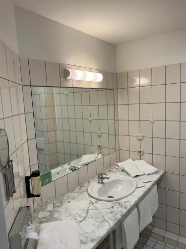 a bathroom with a sink and a mirror at Heide Hotel Reinstorf in Reinstorf