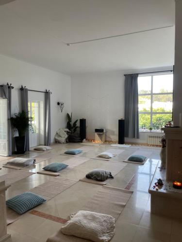 una habitación grande con muchas almohadas en el suelo en Casa do Sol Conscious Coliving, en Óbidos