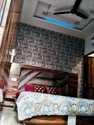 een bed in een kamer met een bakstenen muur bij Hotel Morning Star in Bathinda