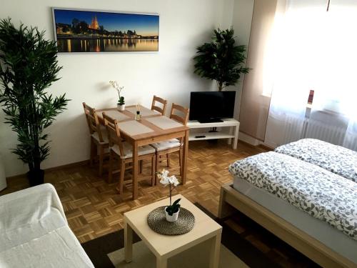 a living room with a dining room table and a bed at Arcaden Apartment in Regensburg