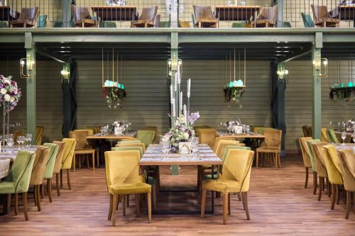 a dining room with tables and chairs with flowers on them at AVO Hotel in Rîmnicu Sărat