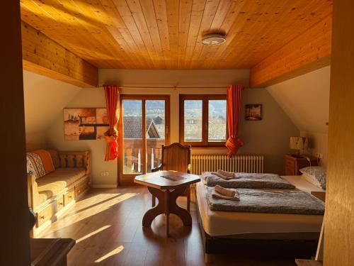 a room with two beds and a couch and a table at Pension Bergseeblick in Titisee-Neustadt