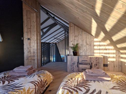 twee bedden in een kamer met houten wanden bij Garden Villa ' Lava Forest ' in Selfoss