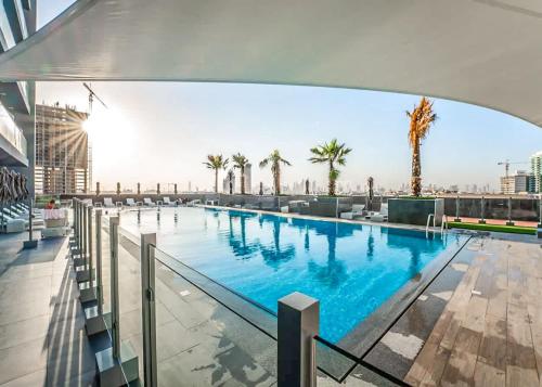 a large swimming pool on top of a building at Free housekeeping visits during your stay - StayShort - Jumeirah Village Circle Studio with Amazing Amenities in Dubai