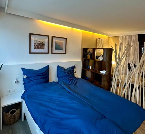 a large blue bed in a bedroom with at Ferienstube alte Teestube Norderney in Norderney