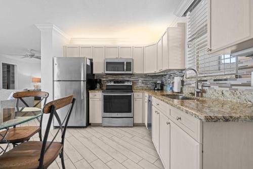 een keuken met witte kasten en roestvrijstalen apparaten bij Penthouse On The Bay 4002 in Bonita Springs