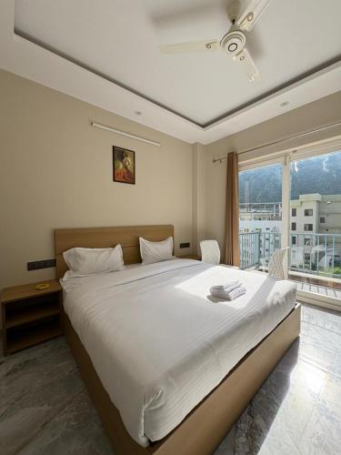 a bedroom with a large white bed and a window at Hotel Abline Rishikesh in Rishīkesh