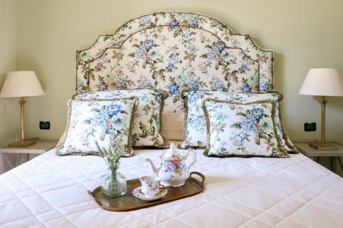 ein Bett mit einem floralen Kopfteil und ein Tablett mit Teesets in der Unterkunft Domus Florum Sorrento in Sorrent