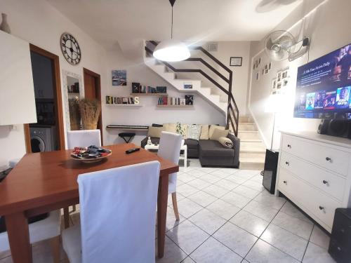 a kitchen and dining room with a table and a staircase at Mare, Roma e Aeroporto - Tutto a portata di mano in Fregene