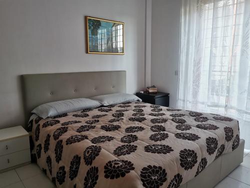 a bedroom with a bed with a black and white comforter at Mare, Roma e Aeroporto - Tutto a portata di mano in Fregene