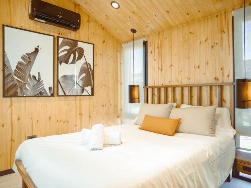 een groot wit bed in een kamer met houten wanden bij Bodega Iaccarini Wine Lodge by BT Homes in San Rafael