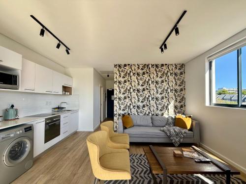 a kitchen and living room with a couch and a table at Urban Escape - Le Jardin Unit 301 in George