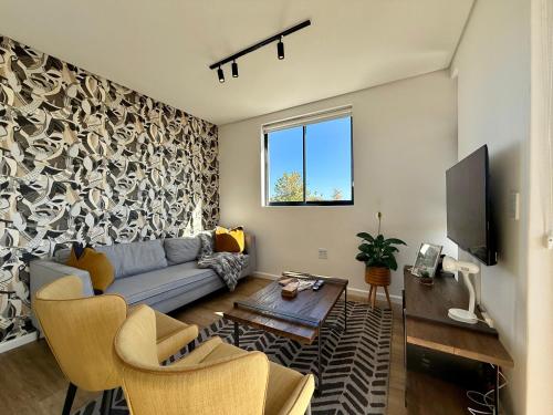 a living room with a couch and a tv at Urban Escape - Le Jardin Unit 301 in George