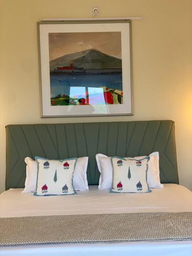 een bed met vier kussens en een foto erboven bij 360 Agonda in Agonda
