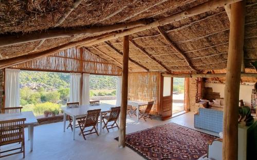 a dining room with a table and chairs and a large window at Oudrif Strawbale Retreat in Clanwilliam