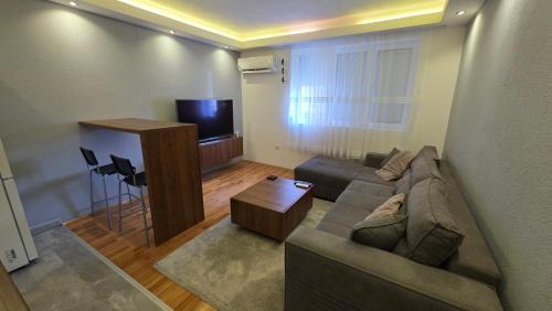 a living room with a couch and a flat screen tv at Bijeljina Central in Bijeljina
