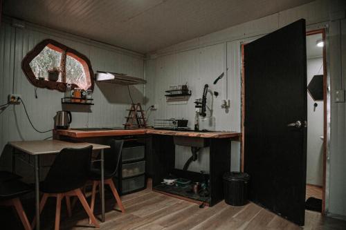 a room with a desk and a table and a door at Dollinco Lodge in El Cerrillo
