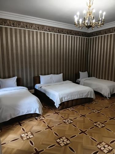 a bedroom with two beds and a chandelier at K17 mini hotel in Tbilisi City