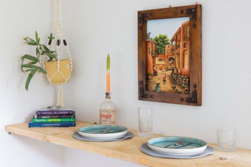 a table with two plates on a shelf with a mirror at Coastal Home for 6 in The Witterings in East Wittering